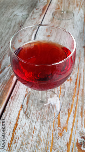 a glass of red wine on a wood table