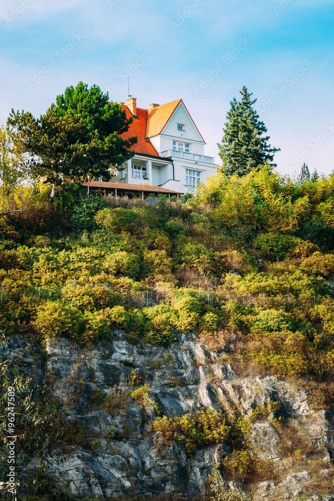 Wooden house cottage on top of cliff or rock, summer evening
