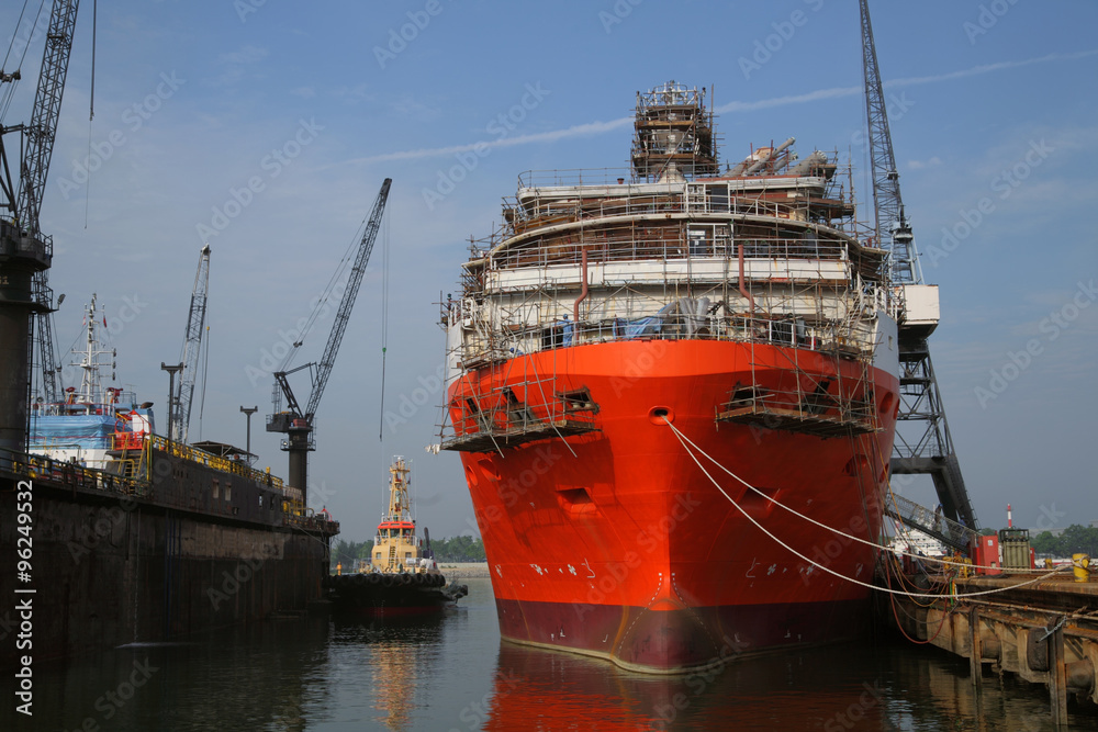 Fototapeta premium Ship under repairs with scaffolding in shipyard