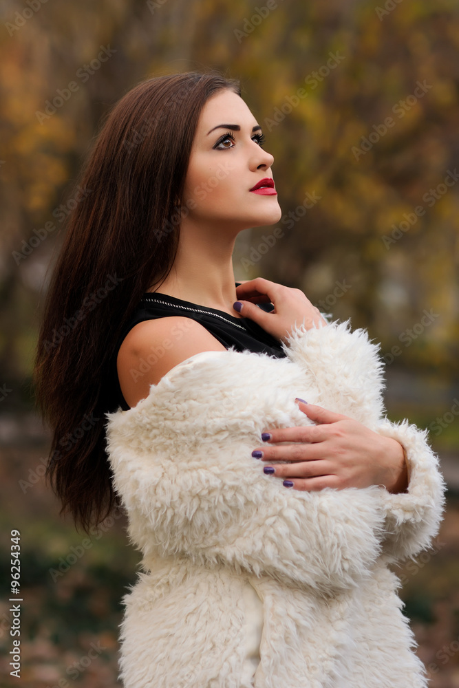 Outdoors portrait of beautiful young woman with big eyes and red