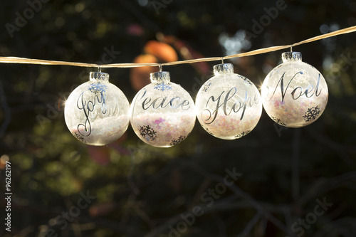 Holiday background Christmas glass ornaments with the words, joy, peace, hope, noel. 
