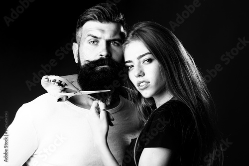 Woman cuttin male beard