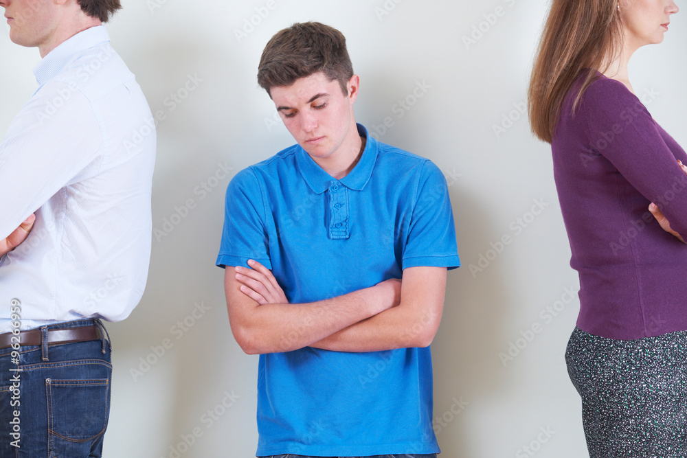 Obraz premium Teenage Boy Standing Between Parents Who Are Ignoring Each Other