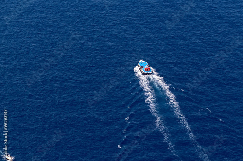 Ship navigates into beautiful blue water near Santorini island, © ververidis