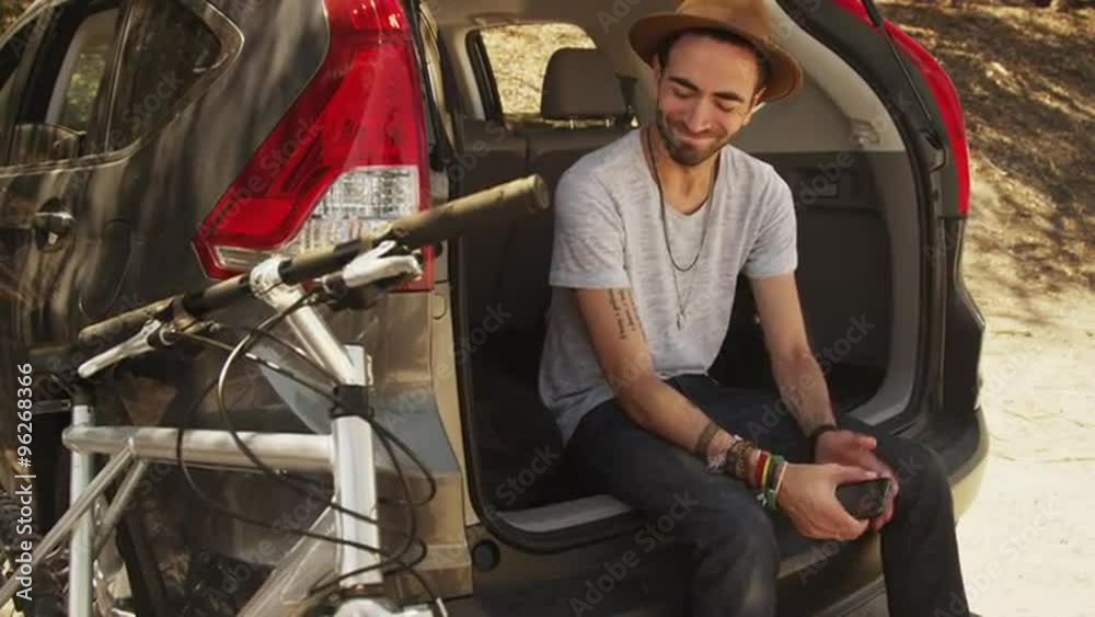 hispanic man sitting in car using smartphone hispanic man sitting in car using smartphone