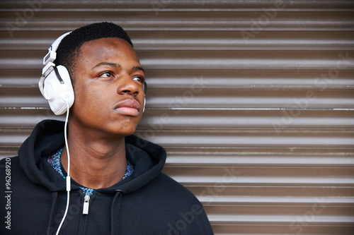 Fotografie Teenage Boy Listening To Music In Urban Setting