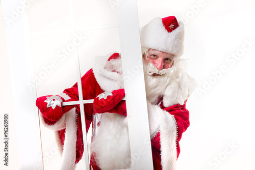 Santa Claus standing bihind the white window photo