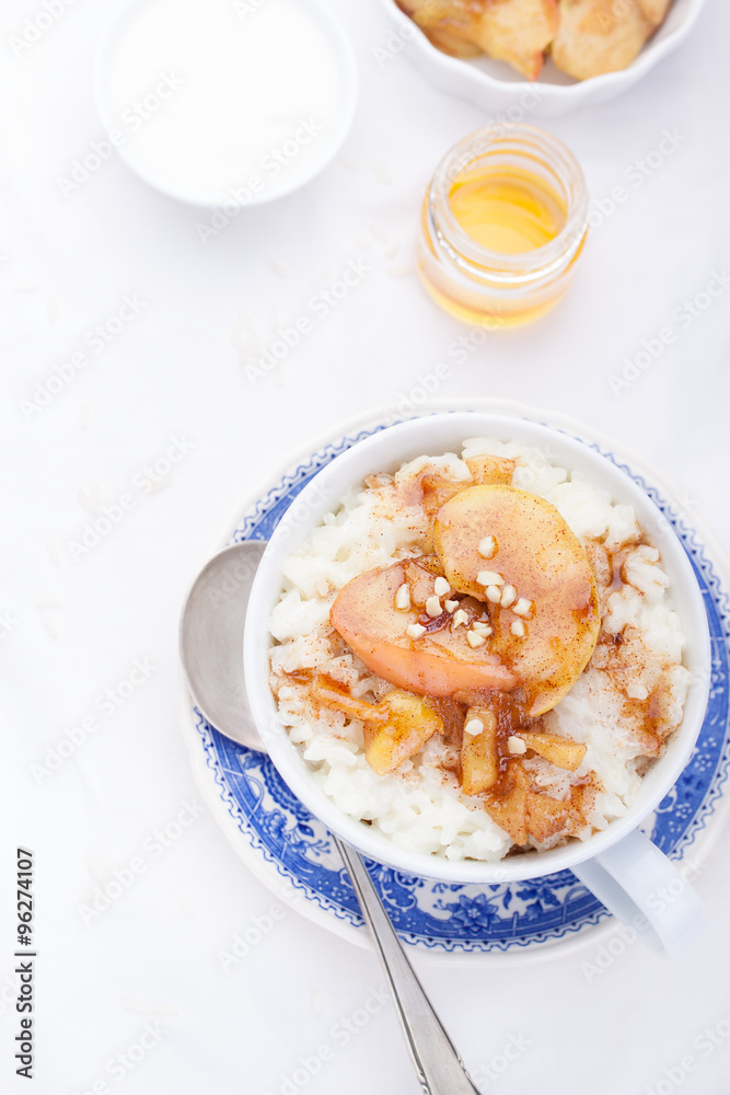 Rice pudding with caramelized apples and honey in a white ceramic cup