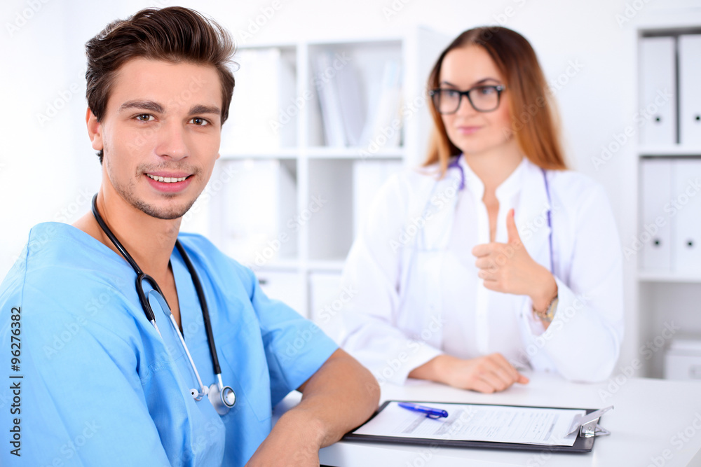Attractive male doctor near female doctor
