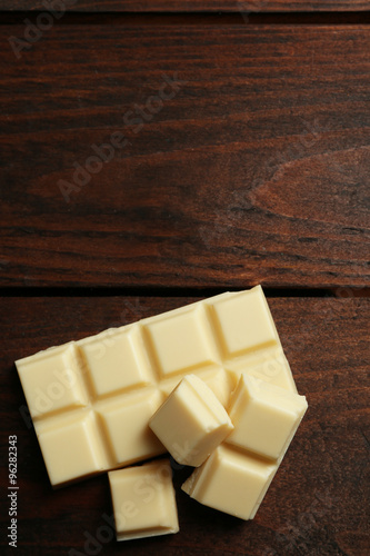 White chocolate pieces on wooden background