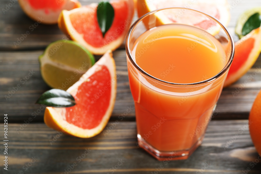 Glass of grapefruit juice and fresh fruits on wooden background Glass of grapefruit juice and fresh fruits on wooden background