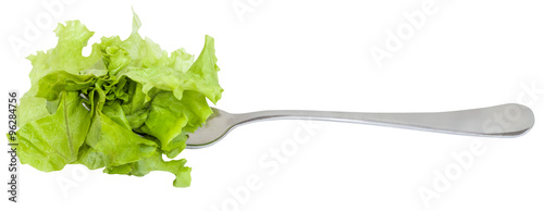 Photos fork with impaled fresh green lettuce isolated