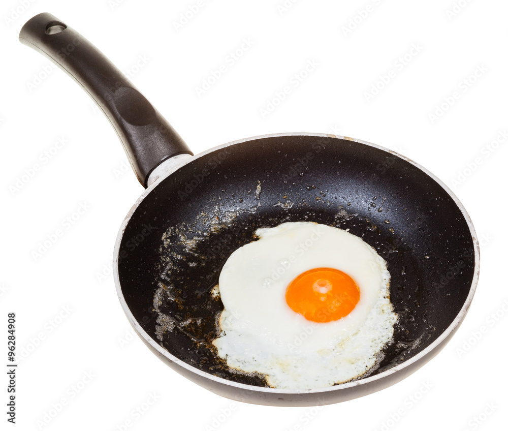 one fried egg in black frypan isolated on white one fried egg in black frypan isolated on white