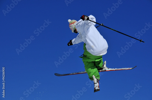 skier in green and white performing a jump