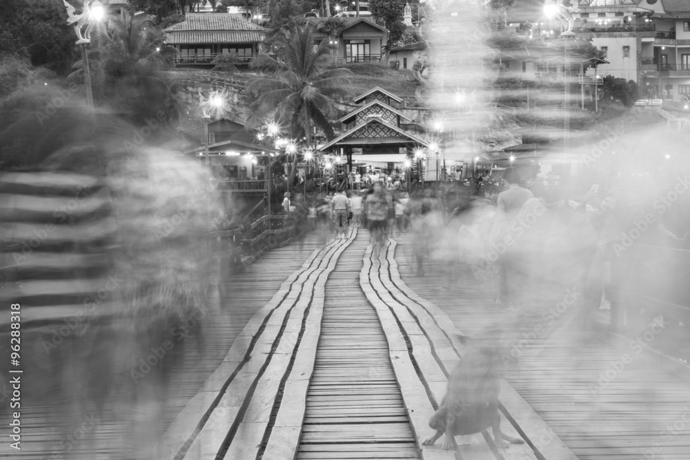 Obraz premium Black and white blur image of Traveler crossing bamboo bridge or Mon Bridge in Sangklaburi. Kanchanaburi, Thailand