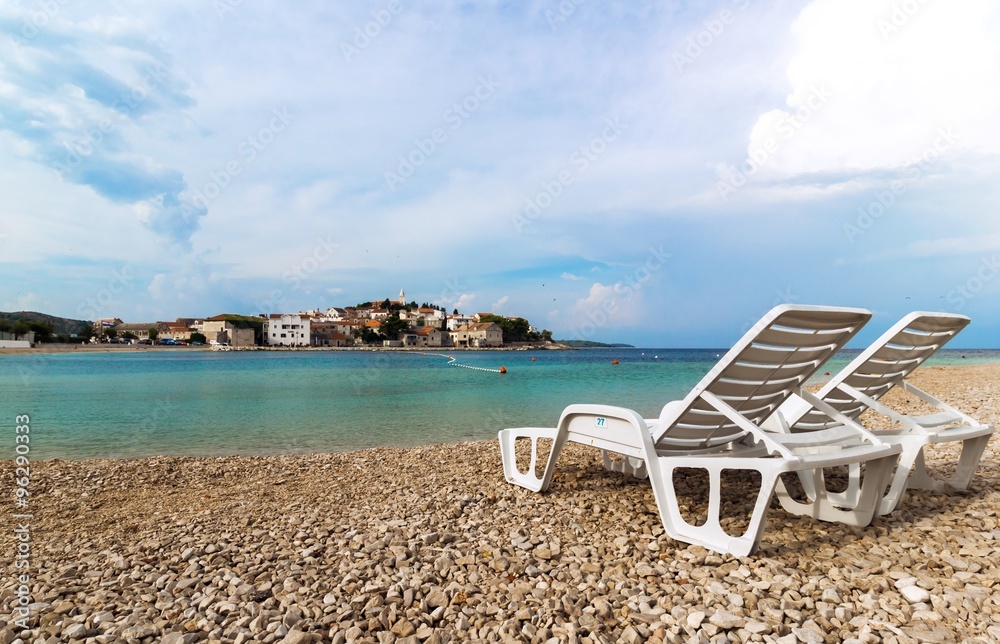 Two white deckchairs on a beautiful beach in Croatia