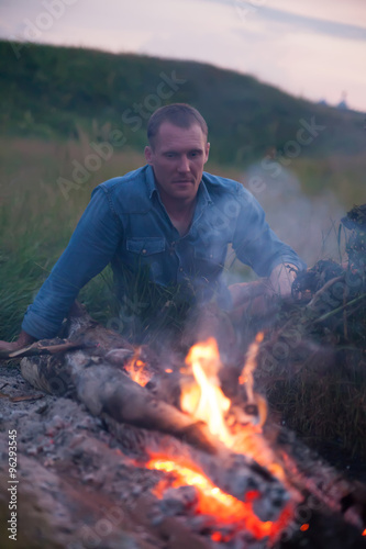 man sitting near bonfire
