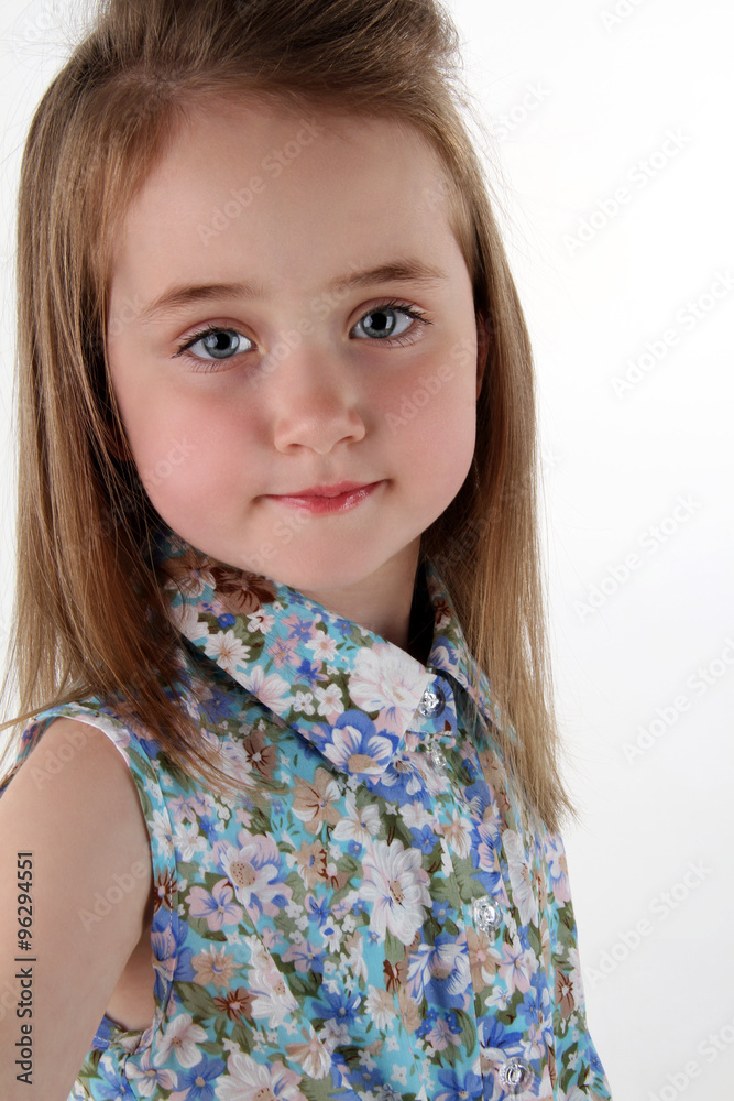 the charming cheerful little girl in a bright shirt poses in the camera the charming cheerful little girl in a bright shirt poses in the camera