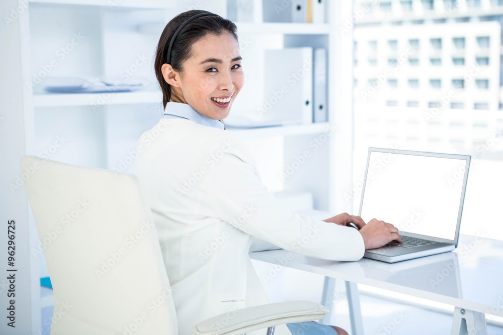 Smiling businesswoman using laptop Smiling businesswoman using laptop