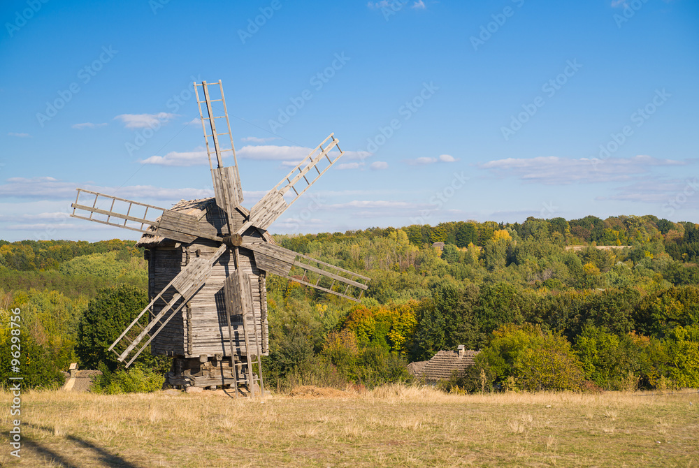 Windmill standing in the field against the blue sky