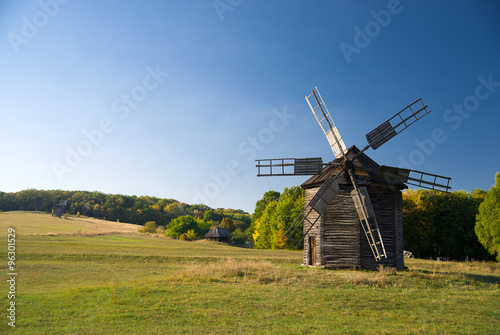 Windmill standing in the field against the blue sky