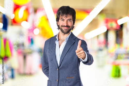 Handsome man with thumb up over white background