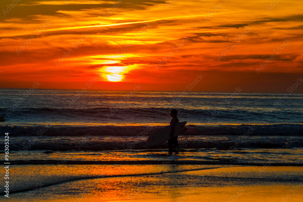 Silhueta do surfista no por do sol vermelho. Praia de Carcavelos em Cascais Portugal
