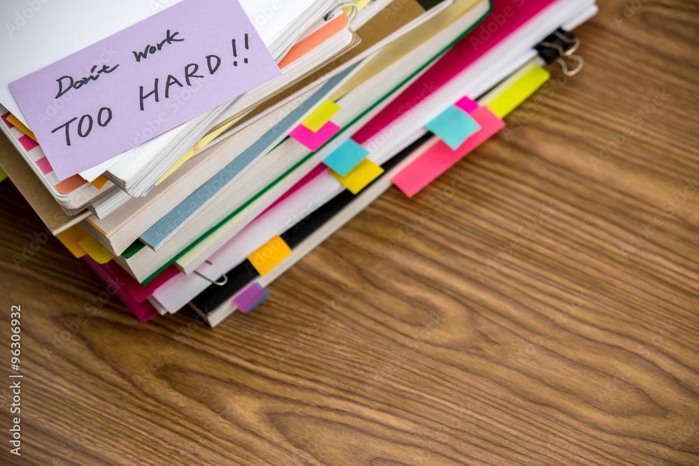 Obraz premium Don't Work Too Hard; The Pile of Business Documents on the Desk