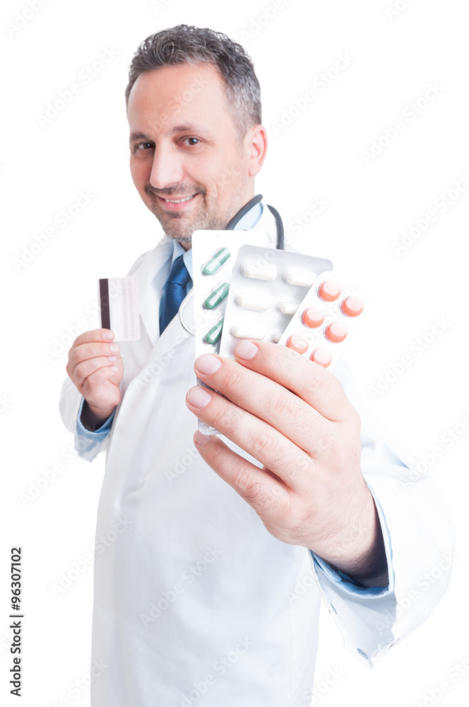 Doctor or medic showing pill tablets and holding credit card Doctor or medic showing pill tablets and holding credit card