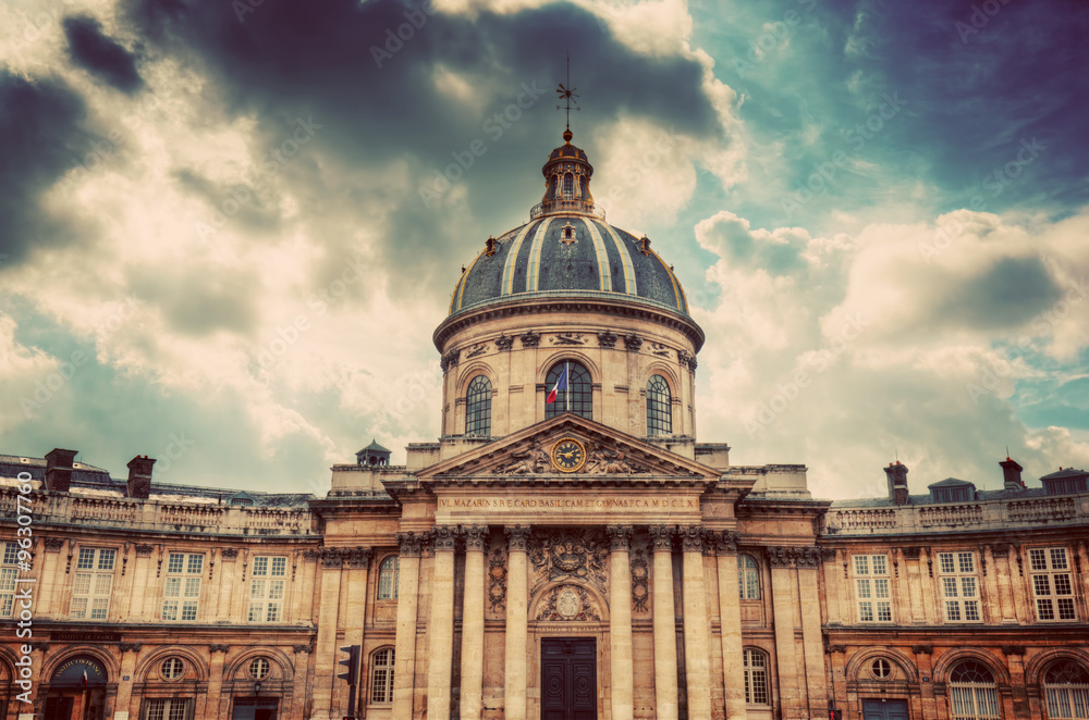 Institut de France in Paris. Famous cupola, dome of the building against clouds.