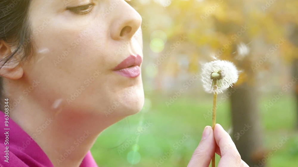 The young woman blowing dandelion in the park in slow motion, Slow Motion Video clip The young woman blowing dandelion in the park in slow motion, Slow Motion Video clip