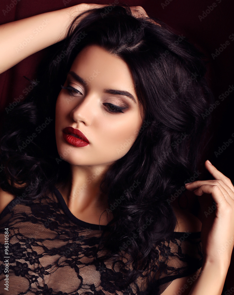 Beautiful woman fashion model with makeup and curly hairstyle in gold  evening gown on black background Stock Photo - Alamy