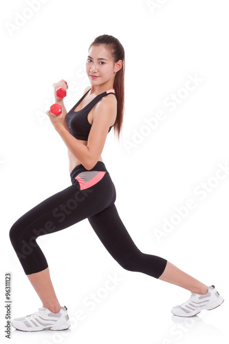 Full length of young woman doing exercise with lifting weights