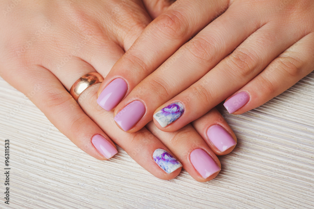 Lilac nail art with printed flowers on light background Lilac nail art with printed flowers on light background