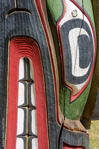 Close up detailing of an Native American carved ancient wooden colorful Totem pole in Victoria at Thunderbird Park, British Columbia, Canada.