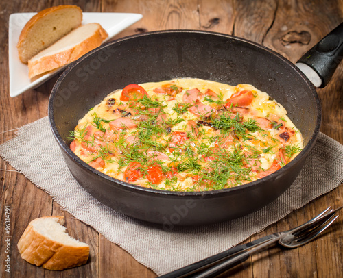 Omelette with sausage, onion, herbs and tomatoes