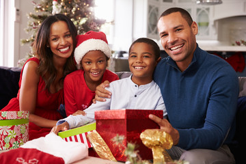 Family Opening Christmas Presents At Home Together