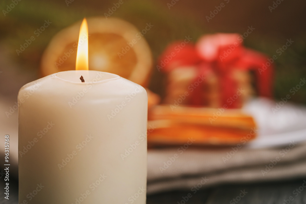 burning candle in front of christmas table, 