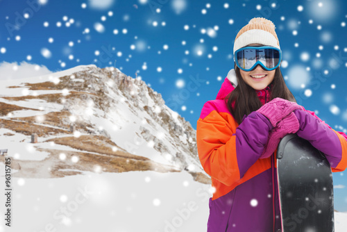 happy young woman with snowboard over mountains