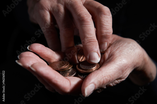 Senior Woman Counting Coins In Hand