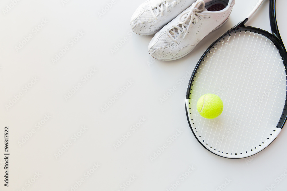 close up of tennis racket with ball and sneakers