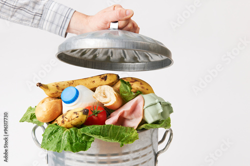 Hand Putting Lid On Garbage Can Full Of Waste Food