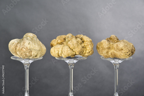 Still life of a truffles placed on the pedestal in glass on black background