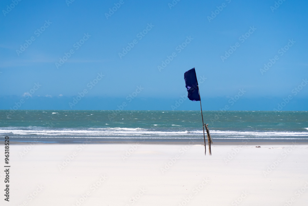 Waving flag on a windy beach, Jericoacoara, Brazil