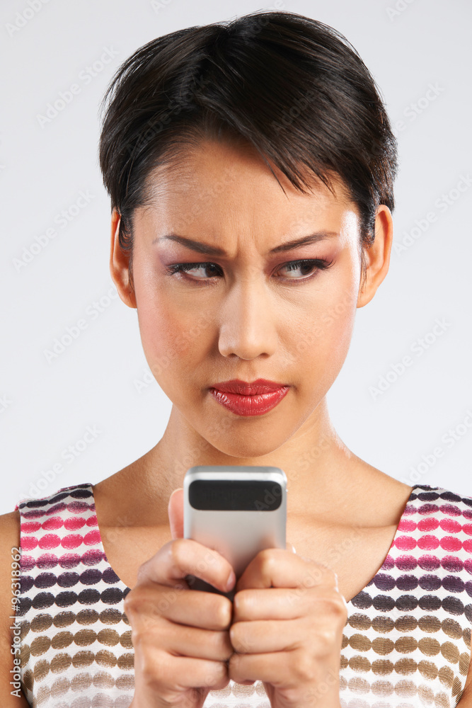 Young Woman Reading Text Message With Annoyed Expression Young Woman Reading Text Message With Annoyed Expression