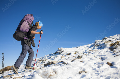 The girl with the backpack is on the slope.