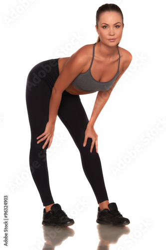 Fitness woman in sport style standing against isolated white background