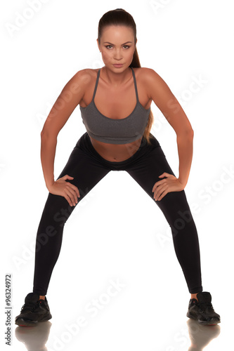 Fitness woman in sport style standing against isolated white background © legull