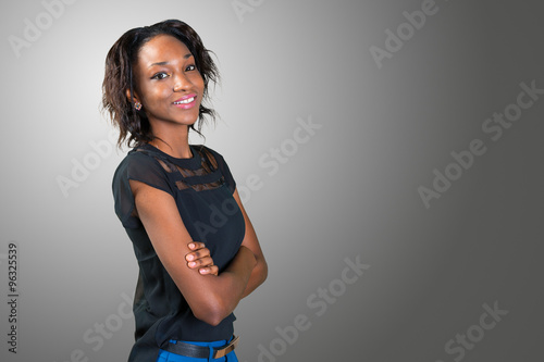 Happy young african woman standing with arms crossed