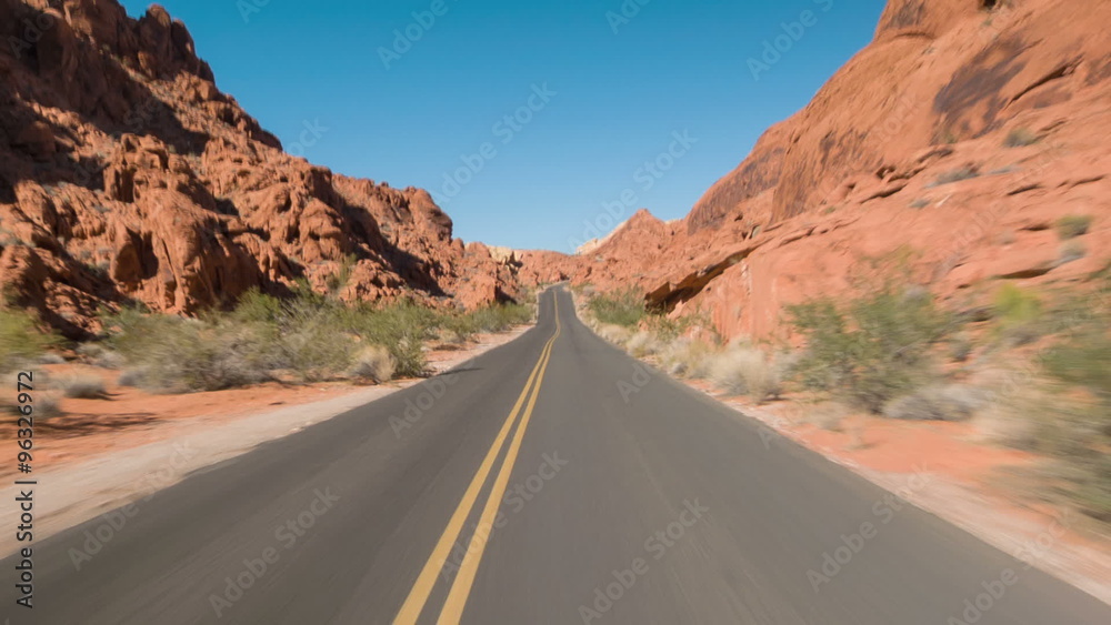 Driving USA: Empty lonely highway through red sandstone formations in Valley of Fire, Nevada Driving USA: Empty lonely highway through red sandstone formations in Valley of Fire, Nevada